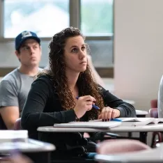 A group of students taking notes in a psychology class.